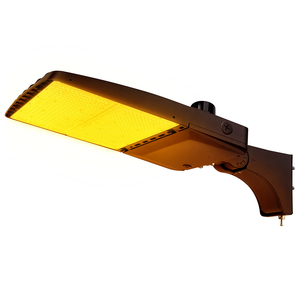 Vela Amber LED Area Light in Dark Bronze with extrusion arm and Photocell.