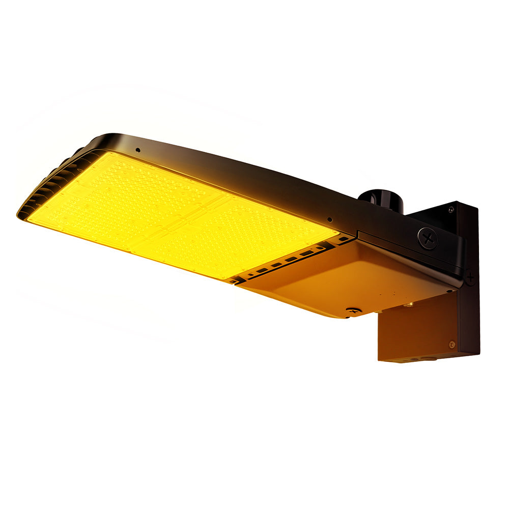 Vela Amber LED Area Light in black with wall mount and photocell.