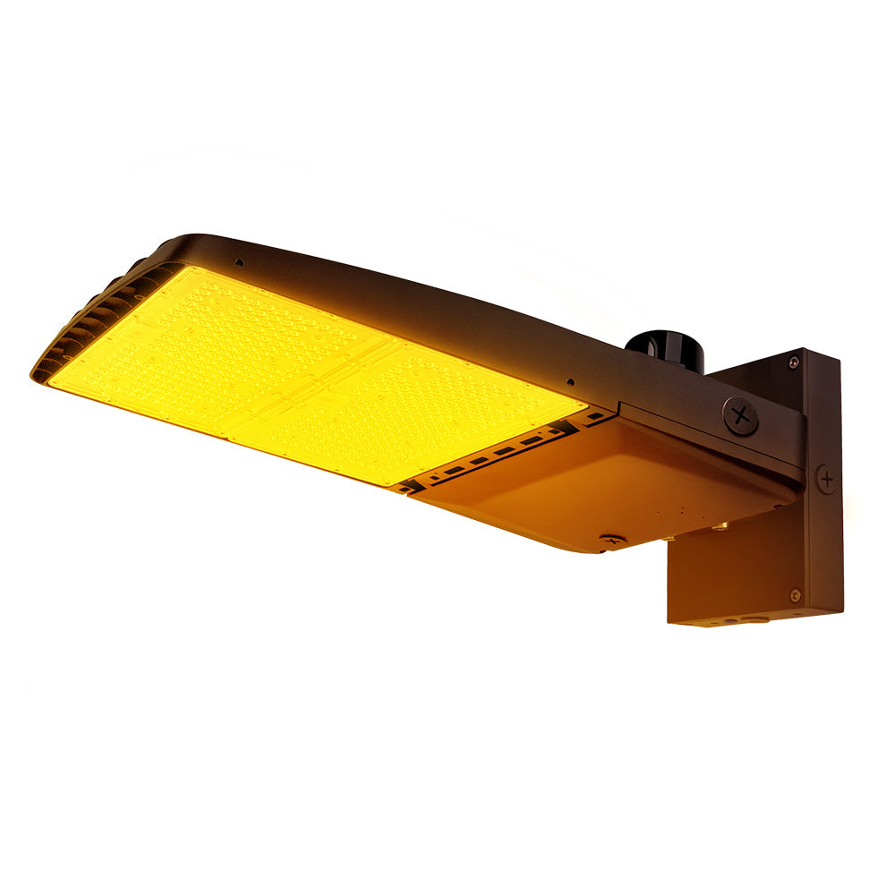 Vela Amber LED Area Light in Dark Bronze with wall mount and Photocell.
