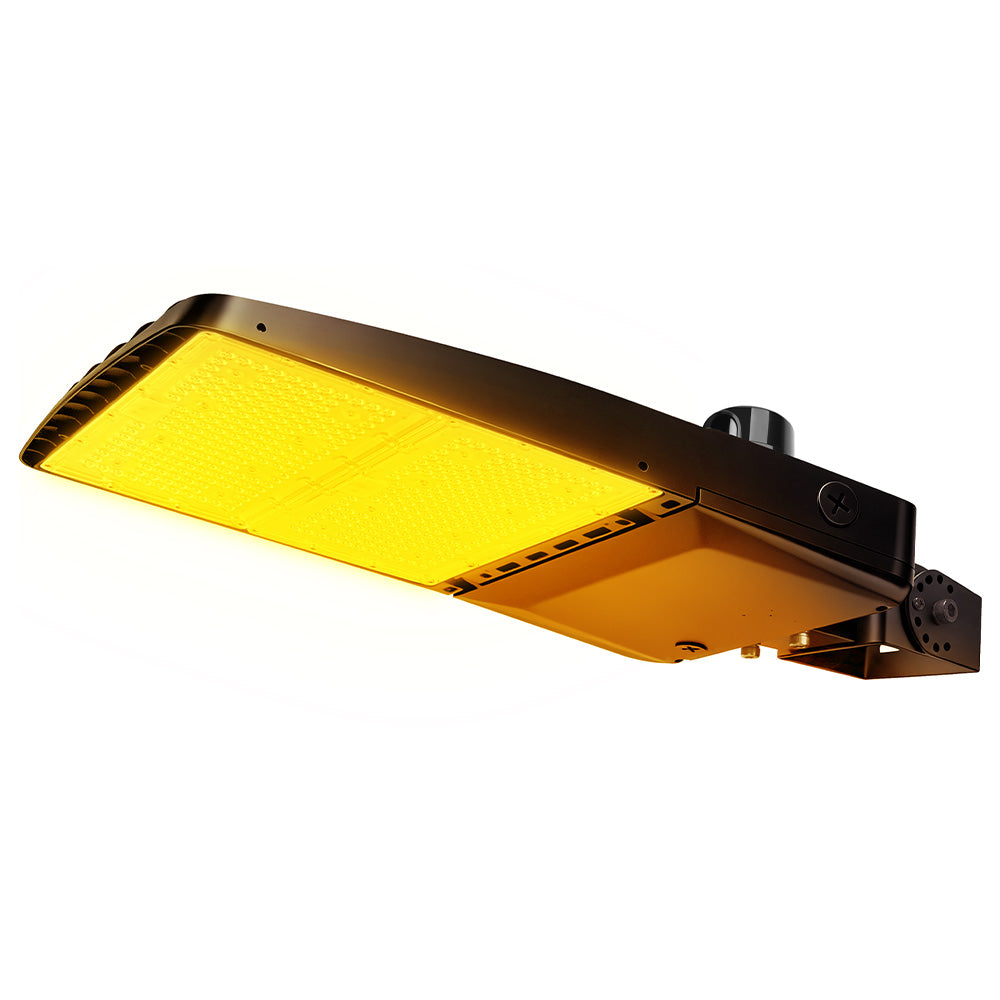 Vela Amber LED Area Light in black with yoke mount and photocell.