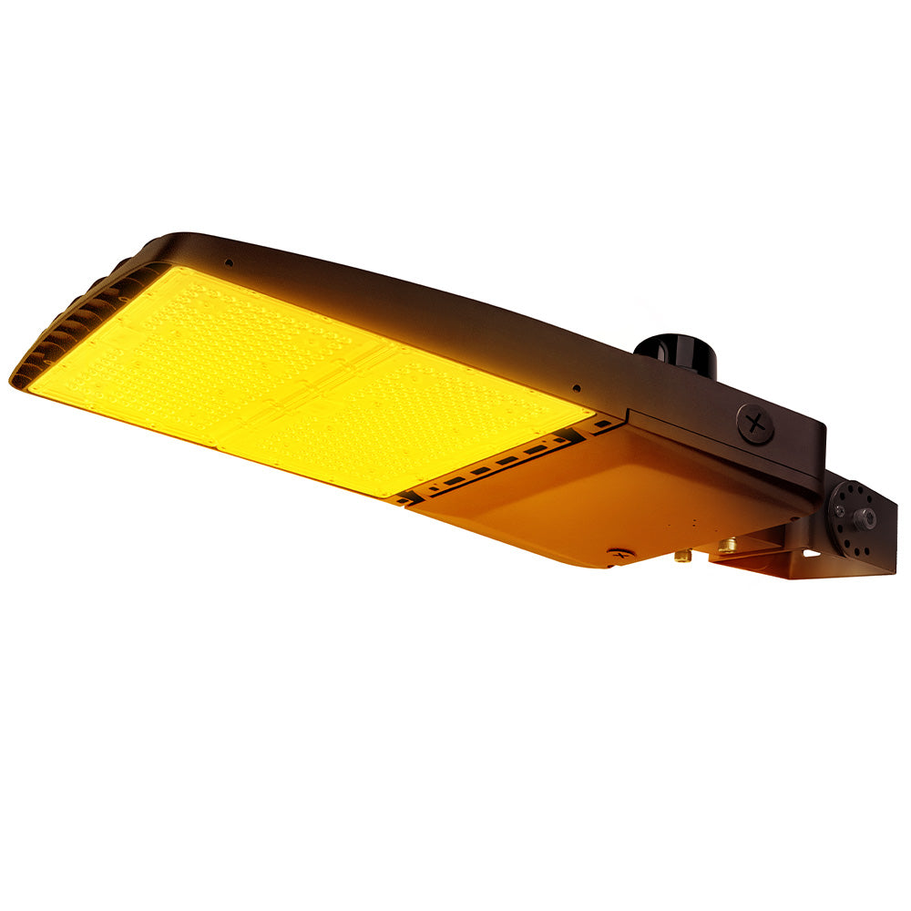 Vela Amber LED Area Light in Dark Bronze with yoke mount and photocell