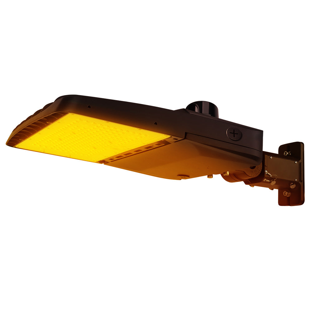 Vela Amber LED Area Light in Dark Bronze with universal mount and photocell