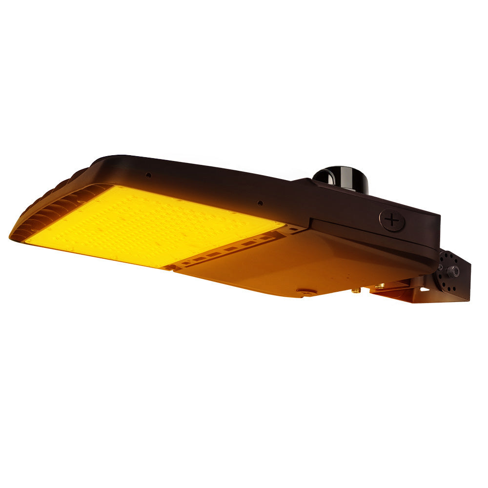Vela Amber LED Area Light in Dark Bronze with yoke mount and photocell