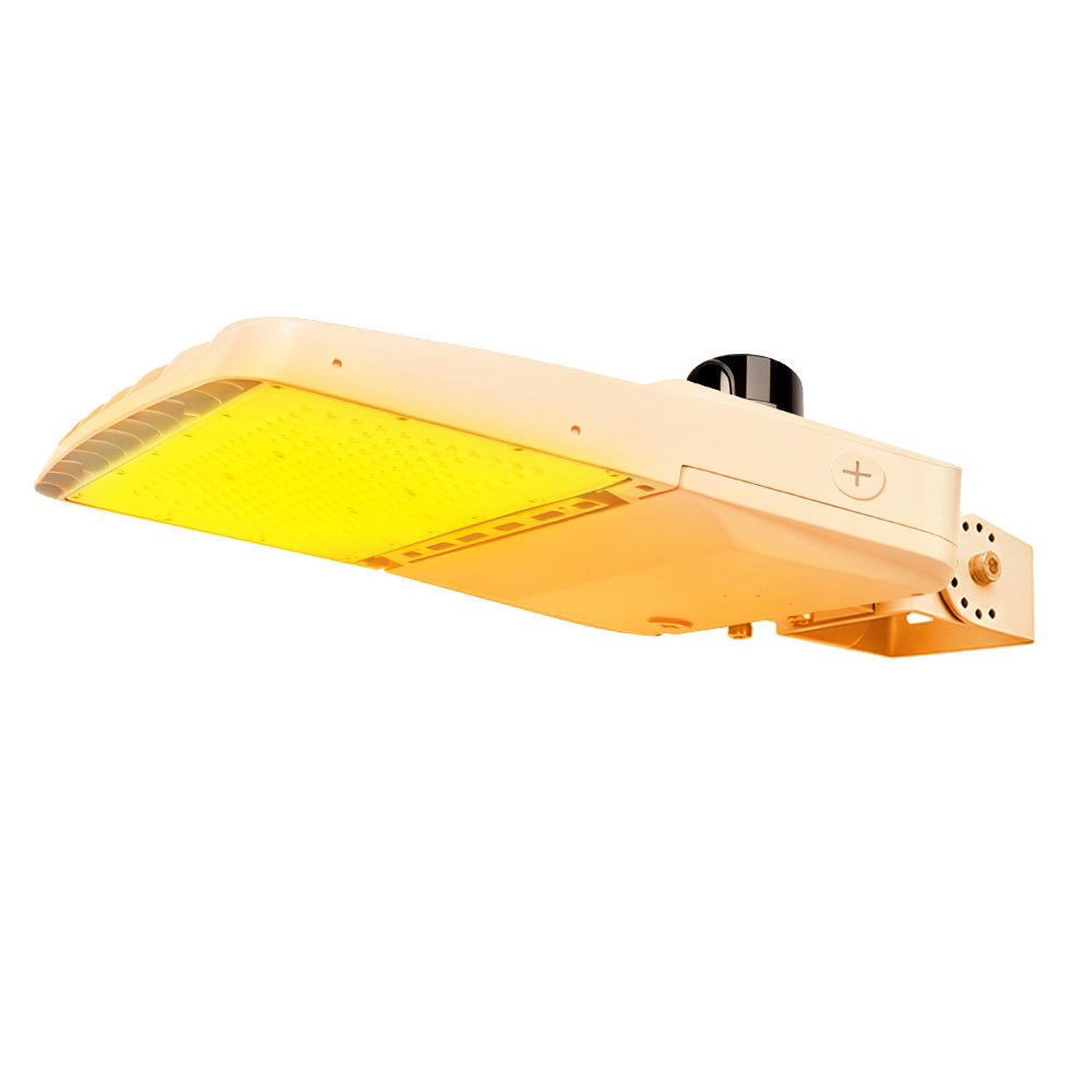 Vela Amber LED Area Light in white with yoke mount and photocell